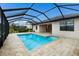 A screened in swimming pool with brick decking is surrounded by lush landscaping and a beautiful backyard at 3512 Scrub Creek Run, Lakewood Ranch, FL 34211