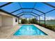 A luxurious swimming pool with a screened-in lanai, surrounded by beautiful landscaping and a lake view at 3512 Scrub Creek Run, Lakewood Ranch, FL 34211