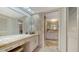 Bathroom featuring a vanity area, neutral stone tiling, and seamless entry into an adjacent bathroom at 3522 Ferndell, Sarasota, FL 34235