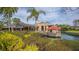 Lush landscape surrounds the clubhouse featuring a waterfront deck, creating a serene outdoor space for dining and relaxation at 3522 Ferndell, Sarasota, FL 34235