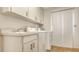 Bright laundry room with washer, dryer, sink, white cabinets, and a sliding glass door at 3522 Ferndell, Sarasota, FL 34235