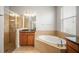 Bathroom showcasing a walk-in shower, soaking tub with granite countertops, and natural light through the window at 358 River Enclave Ct, Bradenton, FL 34212