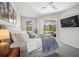 Bedroom with a sliding glass door to lanai with pool views, featuring a TV and soothing natural light at 358 River Enclave Ct, Bradenton, FL 34212