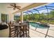 Inviting patio with shaded seating and dining area, overlooking a screened-in pool and lush backyard perfect for outdoor living at 358 River Enclave Ct, Bradenton, FL 34212
