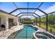 Beautiful screened-in pool and spa surrounded by lush landscaping, offering a private outdoor retreat and leisure space at 358 River Enclave Ct, Bradenton, FL 34212