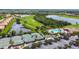 Aerial view of tennis courts and community pool with golf course in the distance at 358 River Enclave Ct, Bradenton, FL 34212