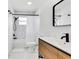 Bathroom featuring floating wood vanity with white countertop, modern black fixtures and shower with white curtain at 3856 Monica Pkwy, Sarasota, FL 34235