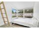 Sunlit bedroom featuring a unique window, light wood floors, and a ladder to a lofted area at 3856 Monica Pkwy, Sarasota, FL 34235