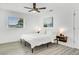 Neutral bedroom with a platform bed, floating nightstands, black ceiling fan and plenty of natural light at 3856 Monica Pkwy, Sarasota, FL 34235