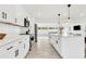 Sleek kitchen featuring white cabinets, marble countertops, stainless steel appliances, and an island with seating at 3856 Monica Pkwy, Sarasota, FL 34235