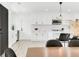 Bright kitchen featuring white cabinetry, marble backsplash, stainless steel appliances, and a modern pendant light fixture at 3856 Monica Pkwy, Sarasota, FL 34235