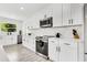 Bright kitchen with white cabinets, stainless steel appliances, marble backsplash, and sleek countertops at 3856 Monica Pkwy, Sarasota, FL 34235