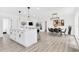 Open-concept kitchen and dining area featuring white cabinets, a large island, and modern pendant lighting at 3856 Monica Pkwy, Sarasota, FL 34235