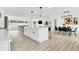 Open-concept kitchen and dining area with white cabinetry, an island, pendant lighting, and modern decor at 3856 Monica Pkwy, Sarasota, FL 34235