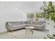 Comfortable living room featuring a sectional sofa, white rug, and a view of the well-lit outdoors at 3856 Monica Pkwy, Sarasota, FL 34235
