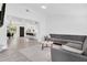 Bright and spacious living room with modern gray sectional sofa, light wood flooring, and open concept design at 3856 Monica Pkwy, Sarasota, FL 34235