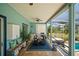 Covered patio area with a table, chairs, grill, bar sink and large screen windows at 408 Inlet Rd, Ruskin, FL 33570