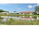Scenic view of homes with varying roof colors reflecting on the water, surrounded by green grass and a clear blue sky at 4131 Salernes Ave # 3051, Sarasota, FL 34233