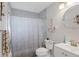 Well-lit bathroom featuring a shower with a patterned curtain, a white vanity, and nautical decor at 4243 Maceachen Blvd, Sarasota, FL 34233