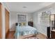 Simple bedroom with a light blue bedspread, wood-look flooring, and two windows for natural light at 4243 Maceachen Blvd, Sarasota, FL 34233