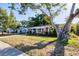 Beautiful brick home with a well-manicured lawn, mature trees, and a welcoming front entrance at 4243 Maceachen Blvd, Sarasota, FL 34233