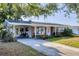 Charming single-story home featuring a brick facade, covered parking, and well-maintained landscaping at 4243 Maceachen Blvd, Sarasota, FL 34233