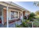 Close-up of a charming brick home featuring a cozy front porch and colorful landscaping at 4243 Maceachen Blvd, Sarasota, FL 34233