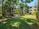 Manicured courtyard of a condo building shows lush lawn, sidewalks, and tropical landscaping at 425 30Th W Ave # C104, Bradenton, FL 34205