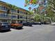 Exterior view of a multi-story condo building with parking lot featuring reserved parking spaces at 425 30Th W Ave # C104, Bradenton, FL 34205
