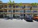 Exterior of a condo building with balconies, palm trees, and reserved parking spaces at 425 30Th W Ave # C104, Bradenton, FL 34205