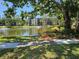 Scenic pond view from a multi-story condo building with fountains and mature trees on a sunny day at 425 30Th W Ave # C104, Bradenton, FL 34205