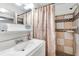 Bright bathroom features a white vanity, a mirror, patterned shower curtain, and tiled shower at 432 Crosby Ct, Sarasota, FL 34237