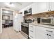 Well-lit kitchen featuring white cabinets, stainless steel appliances, and stylish tile backsplash at 432 Crosby Ct, Sarasota, FL 34237