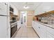 Bright kitchen features sleek white cabinetry, mosaic tile backsplash, and stainless steel appliances at 432 Crosby Ct, Sarasota, FL 34237