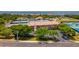Aerial view of community featuring mature trees, tennis courts, and building at 4510 El Conquistador Pkwy # 105, Bradenton, FL 34210