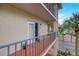 Private balcony with railing, outdoor lighting, and unit number offers a cozy retreat, complemented by lush greenery at 4510 El Conquistador Pkwy # 105, Bradenton, FL 34210
