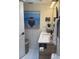 Modern bathroom with stylish vanity, round mirror, boat art, and patterned floor tiles at 4510 El Conquistador Pkwy # 105, Bradenton, FL 34210