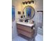 Modern bathroom with stylish vanity, round mirror, boat art and patterned floor tiles at 4510 El Conquistador Pkwy # 105, Bradenton, FL 34210