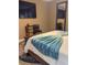 A bedroom featuring a queen bed, blue throw, a full-length mirror, TV and a small end table at 4510 El Conquistador Pkwy # 105, Bradenton, FL 34210