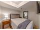 Cozy bedroom with a comfortable bed, a bedside table, and a mirror reflecting a lamp, creating a relaxing atmosphere at 4510 El Conquistador Pkwy # 105, Bradenton, FL 34210