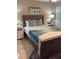 A bedroom showcasing a queen bed, blue throw blanket, two end tables with lamps and a painting above the bed at 4510 El Conquistador Pkwy # 105, Bradenton, FL 34210