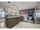 Open concept kitchen with center island, stainless appliances, pendant lights, and tiled floor at 4510 El Conquistador Pkwy # 105, Bradenton, FL 34210