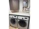 Functional laundry room with a side-by-side washer and dryer, quartz countertop, storage cabinet, and tankless water heater at 4510 El Conquistador Pkwy # 105, Bradenton, FL 34210
