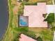 Aerial view of a home with a red tile roof, pool, mature landscaping and lake access at 4613 Sweetmeadow Cir, Sarasota, FL 34238