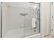 Bright bathroom with white tile, shower-tub combo, glass enclosure and accessibility bars at 4613 Sweetmeadow Cir, Sarasota, FL 34238