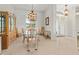 Bright dining room featuring modern chandelier, glass table and seamless access to other rooms at 4613 Sweetmeadow Cir, Sarasota, FL 34238