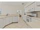 Well-lit kitchen with white cabinets and appliances, and tile flooring at 4613 Sweetmeadow Cir, Sarasota, FL 34238