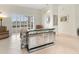 Bright living room featuring a mirrored bar, tile flooring, and sliding glass doors to outdoor views at 4613 Sweetmeadow Cir, Sarasota, FL 34238