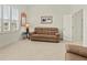 Bright living room features a tan sofa and light tile flooring and bright white walls and natural lighting at 4613 Sweetmeadow Cir, Sarasota, FL 34238