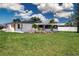 Spacious backyard with a well-maintained lawn and mature palm trees at 466 Sunnyside Dr, Venice, FL 34293